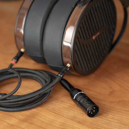 Adaptorul Fosi Audio I5 conectat la cablul unor căști over-ear