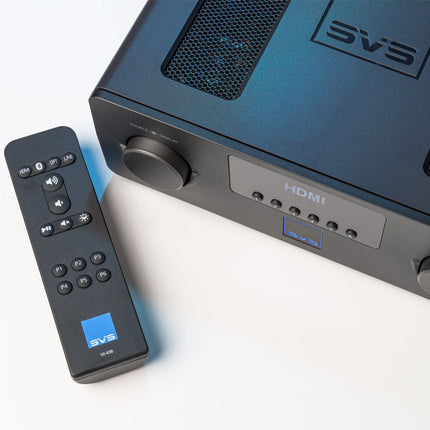 SVS Prime Wireless Pro Soundbase, vedere de sus-lateral cu grila de ventilație și telecomanda sprijinită în față
