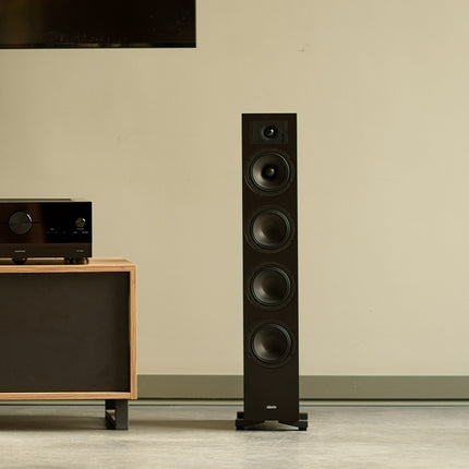 Indiana Line Diva 6 neagră, într-o cameră, lângă o comodă cu un receiver