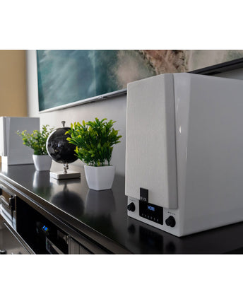 SVS Prime Wireless Pro, finisaj Piano Gloss White, boxa în prim-plan pe o comodă, cu televizorul în fundal