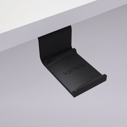 Suport Kanto Audio HH negru prins sub tăblia unui birou, văzut de jos
