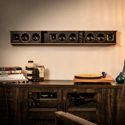 Klipsch Heritage Theater Bar montat pe perete fara grila, deasupra unui bufet cu receiver si pick-up