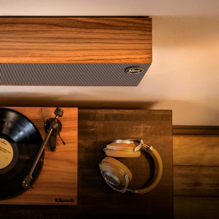 Klipsch Heritage Theater Bar in furnir de nuc, montat pe perete deasupra unui pick-up si a unei perechi de casti