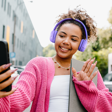 Căști JBL Tune 530BT lavandă, purtate în oraș, la un selfie