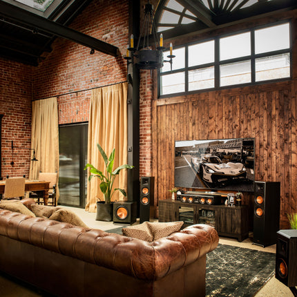 Sistem de home cinema Klipsch Reference Premiere intr-un living, cu canalul central asezat pe comoda imediat sub televizor
