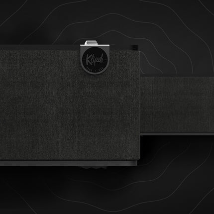 Doua boxe Klipsch The One Plus in finisaj Ebony, alaturate, ilustrand functia Broadcast Mode