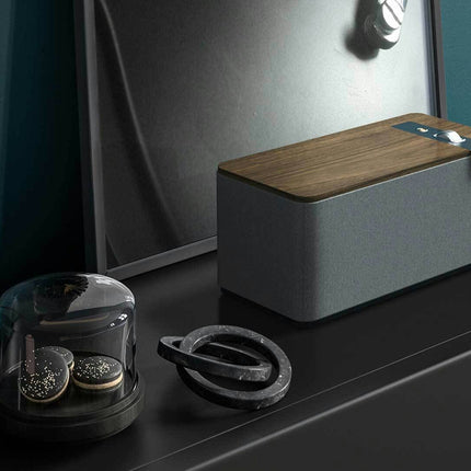 Boxa Klipsch The One Plus in finisaj Walnut, asezata pe o comoda dintr-un interior modern