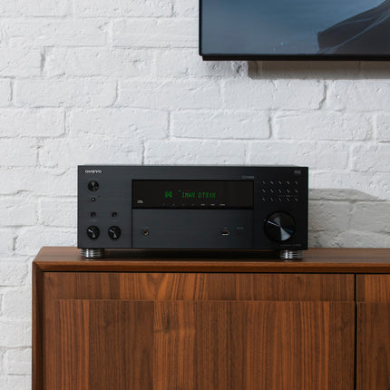 Receiverul Onkyo TX-RZ30 sub un televizor montat pe perete, intr-un living