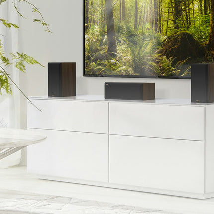 Klipsch RP-500C II in Walnut sub televizor, incadrat de doua boxe de raft RP-500M II vandute separat