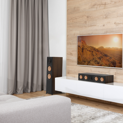 Klipsch RP-504C II in finisaj Walnut, sub un televizor, langa o boxa de podea