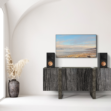 Klipsch RP-600M II Ebony pe o consola de lemn, sub televizor