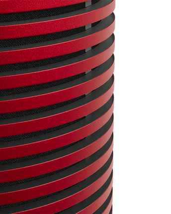 Detaliu macro al grilajului din aluminiu anodizat roșu al Beosound Explore Ferrari Edition