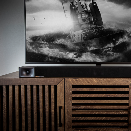 Soundbar Klipsch Cinema 600 asezat pe o comoda de lemn, sub televizor