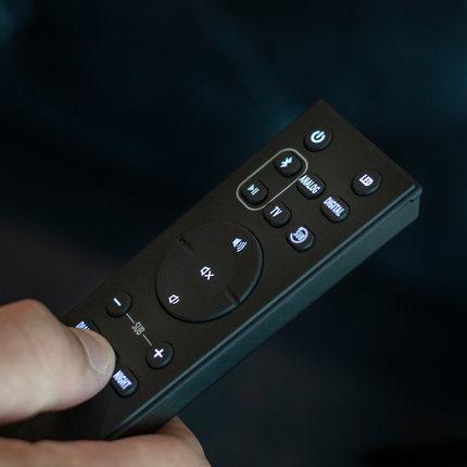Telecomanda soundbarului Klipsch Cinema 600, cu butoanele iluminate