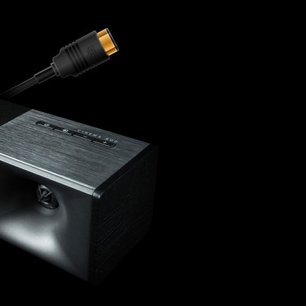 Capatul barei Klipsch Cinema 800 cu palnia Tractrix, comenzile de pe panoul superior si un cablu HDMI