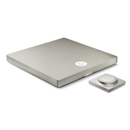 Amplificatorul Devialet Astra în finisajul Light Bronze, văzut în trei sferturi, cu telecomanda alături