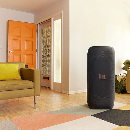 Boxa JBL PartyBox Ultimate în husa JBL PartyCover Ultimate, într-un cadru de petrecere