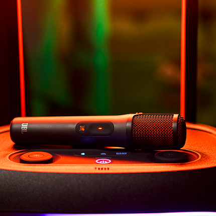 Microfon JBL EasySing Mics așezat pe o boxă JBL PartyBox
