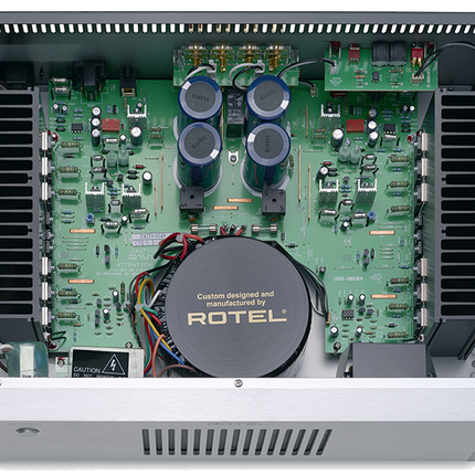 Interiorul Rotel RB-1552 MkII: transformatorul de alimentare, cele patru condensatoare de stocare și radiatoarele laterale ale celor două canale
