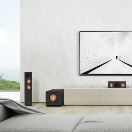 Living luminos cu un sistem Klipsch Reference Premiere: boxă de podea, canal central și un subwoofer pe pardoseală