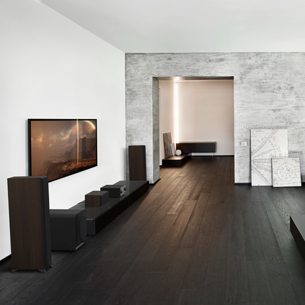 Interior modern cu un sistem Klipsch Reference Premiere și un subwoofer așezat lângă comodă