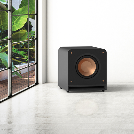 Subwooferul Klipsch RP-1000SW, fără grilă, lângă o fereastră mare
