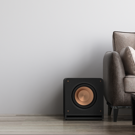 Klipsch RP-1200SW lângă o canapea, într-o cameră luminoasă