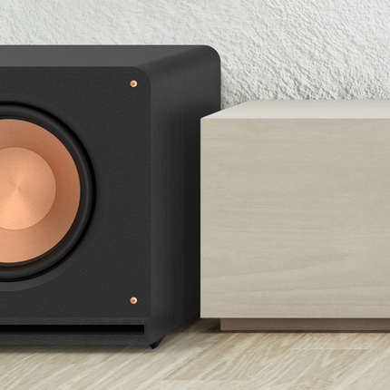Subwoofer Klipsch Reference Premiere langa o comoda, intr-un living