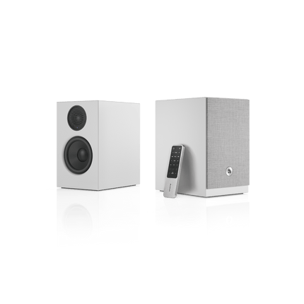 Pereche Audio Pro A28 W albă, cu telecomanda Audio Pro sprijinită de boxa dreaptă